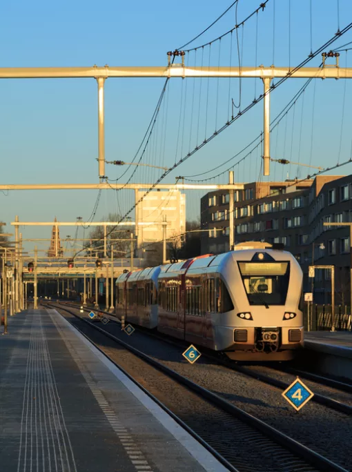 Train leaving a station in the city on a winter morning.