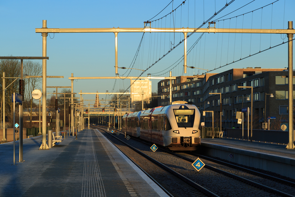 Train leaving a station in the city on a winter morning.